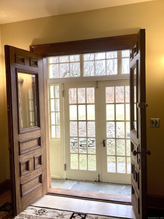 entryway with french doors and light tile patterned floors