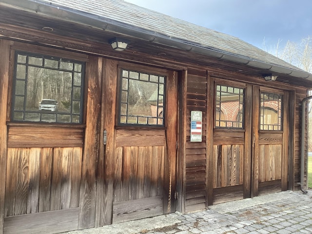 doorway to property with a shingled roof