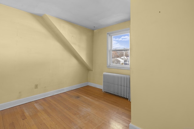 unfurnished room featuring radiator heating unit and wood-type flooring