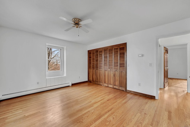 unfurnished bedroom with light wood-type flooring, ceiling fan, and a baseboard heating unit