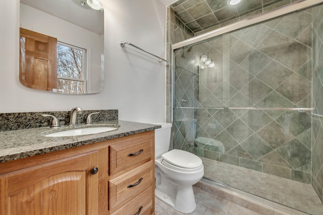 bathroom with vanity, toilet, and a shower with shower door