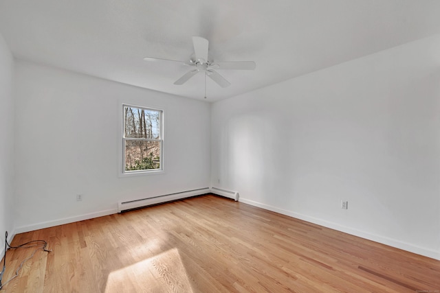 spare room featuring light wood-type flooring, baseboard heating, and ceiling fan