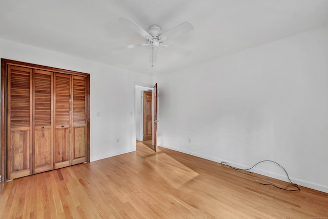 unfurnished bedroom with ceiling fan, a closet, and light hardwood / wood-style floors