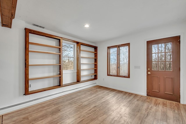 entryway with light wood-type flooring and baseboard heating