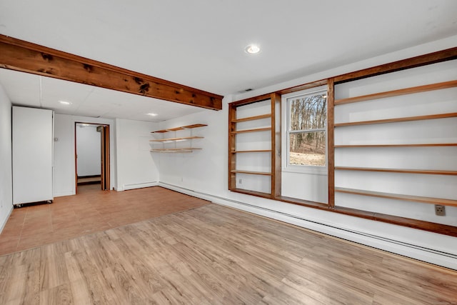 unfurnished living room with a baseboard radiator and light hardwood / wood-style flooring