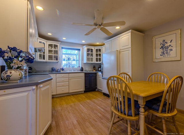 kitchen featuring decorative backsplash, white cabinetry, and black dishwasher