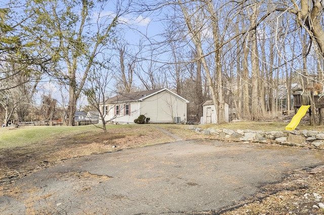 view of home's exterior featuring central AC and a shed