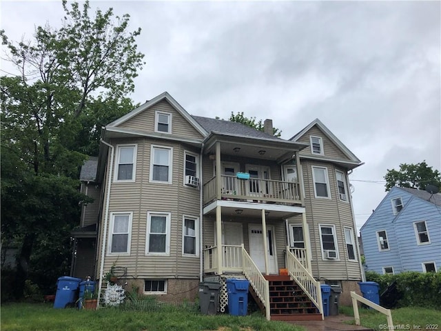 view of front of property featuring cooling unit and a balcony