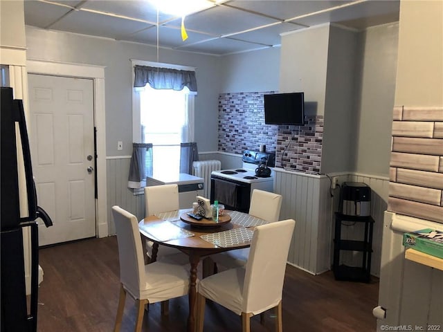 dining space featuring dark hardwood / wood-style flooring and radiator heating unit