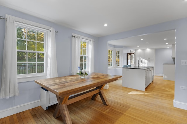 dining space featuring light wood-type flooring and sink