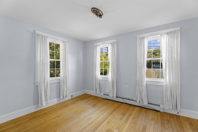 spare room featuring light hardwood / wood-style flooring and a baseboard heating unit