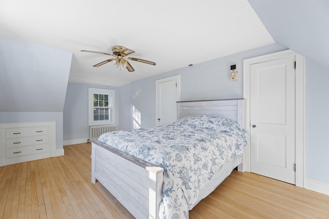 bedroom featuring ceiling fan, light hardwood / wood-style flooring, lofted ceiling, and radiator heating unit