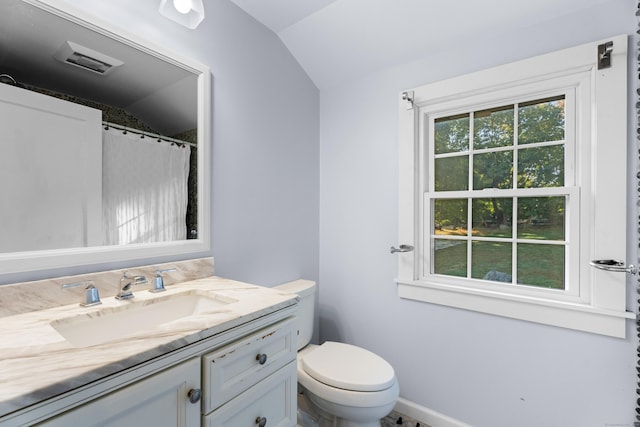 bathroom with vanity, toilet, and lofted ceiling