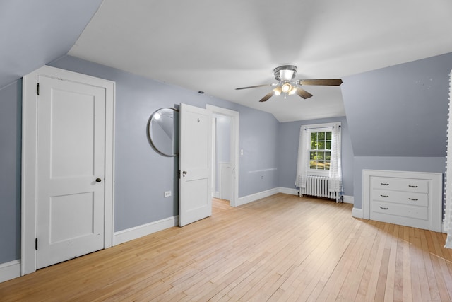 bonus room featuring light hardwood / wood-style floors, radiator, lofted ceiling, and ceiling fan