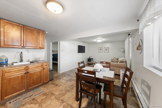 dining space with sink and a baseboard heating unit