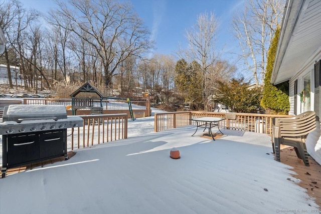 snow covered deck with a grill