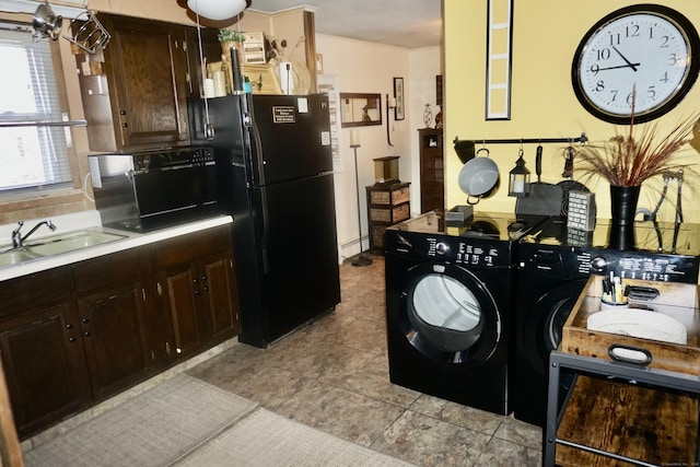 kitchen with light tile patterned floors, black fridge, independent washer and dryer, dark brown cabinetry, and sink