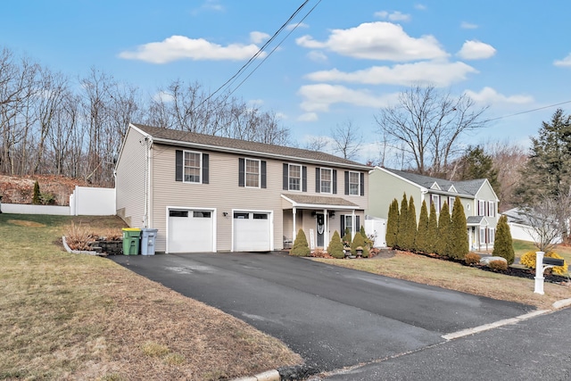 view of front of property featuring covered porch, a garage, and a front yard