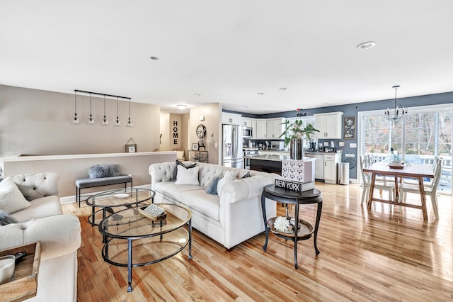 living room with a chandelier and light hardwood / wood-style flooring