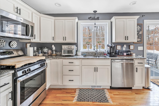 kitchen featuring light hardwood / wood-style floors, white cabinetry, sink, and appliances with stainless steel finishes