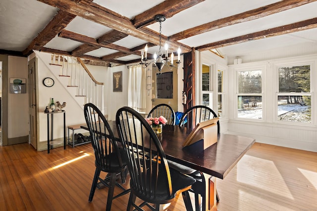 dining area with beam ceiling, light wood-type flooring, and an inviting chandelier