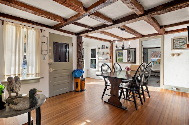 dining space with beam ceiling, a chandelier, light hardwood / wood-style floors, and coffered ceiling