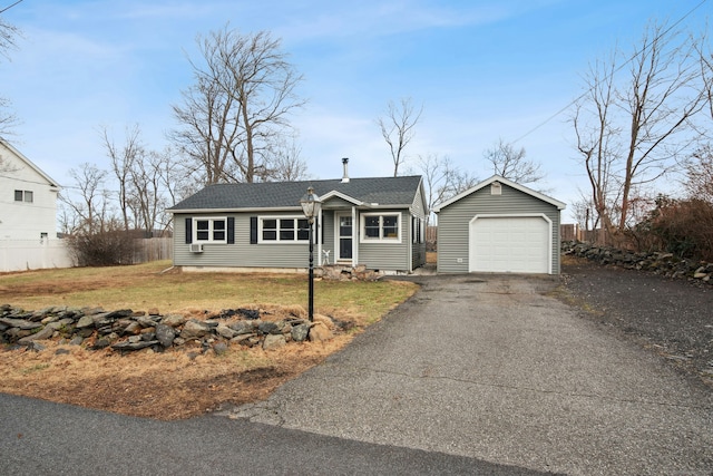 single story home featuring a front yard, a garage, and an outdoor structure