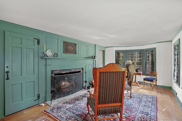 living room with light hardwood / wood-style flooring and crown molding