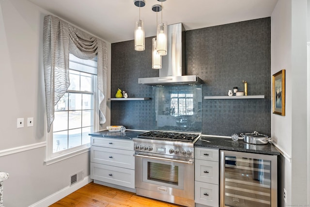 kitchen featuring light hardwood / wood-style floors, white cabinetry, stainless steel stove, wine cooler, and range hood