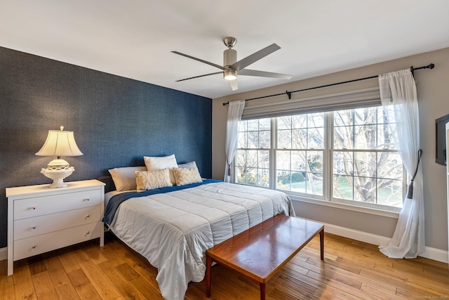 bedroom featuring multiple windows, light wood-type flooring, and ceiling fan