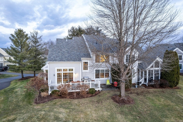 rear view of property with a deck and a yard