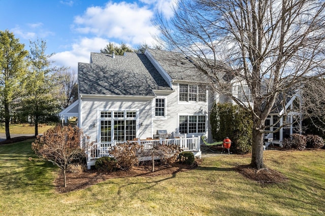 rear view of property with a deck and a lawn