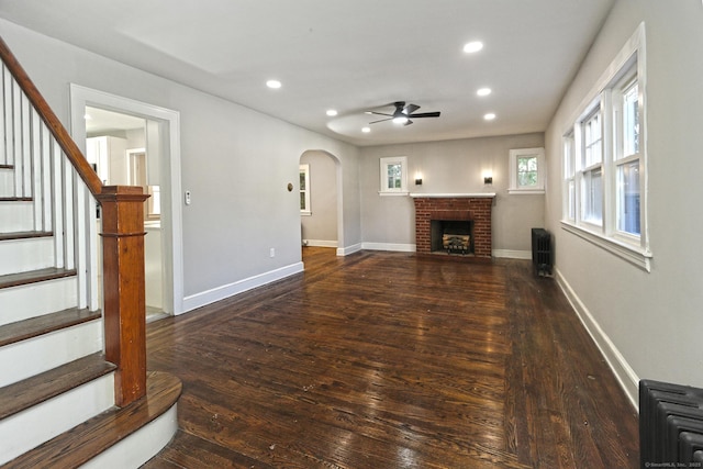 living room with ceiling fan, a fireplace, and dark hardwood / wood-style floors