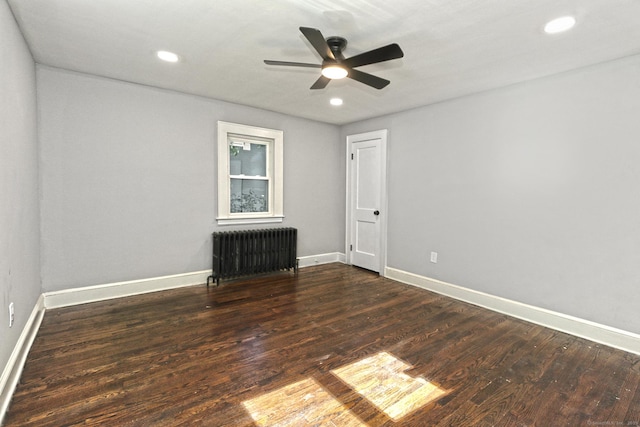 spare room featuring radiator, ceiling fan, and dark hardwood / wood-style floors