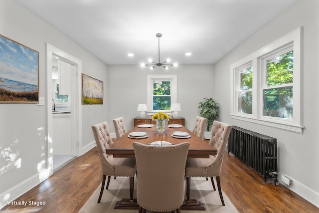 dining room featuring radiator, dark wood-type flooring, a chandelier, and sink