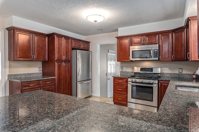 16 Snow Rdg S, Middletown, CT 06457 - kitchen featuring a textured ceiling, tasteful backsplash, a sink, dark stone countertops, and stainless steel appliances