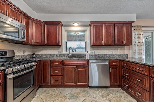 16 Snow Rdg S, Middletown, CT 06457 - kitchen featuring a textured ceiling, a sink, reddish brown cabinets, dark stone counters, and stainless steel appliances