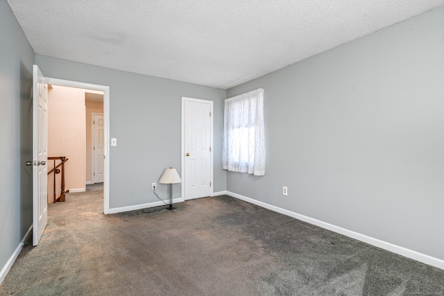 16 Snow Rdg S, Middletown, CT 06457 - unfurnished bedroom featuring a textured ceiling, baseboards, and dark carpet