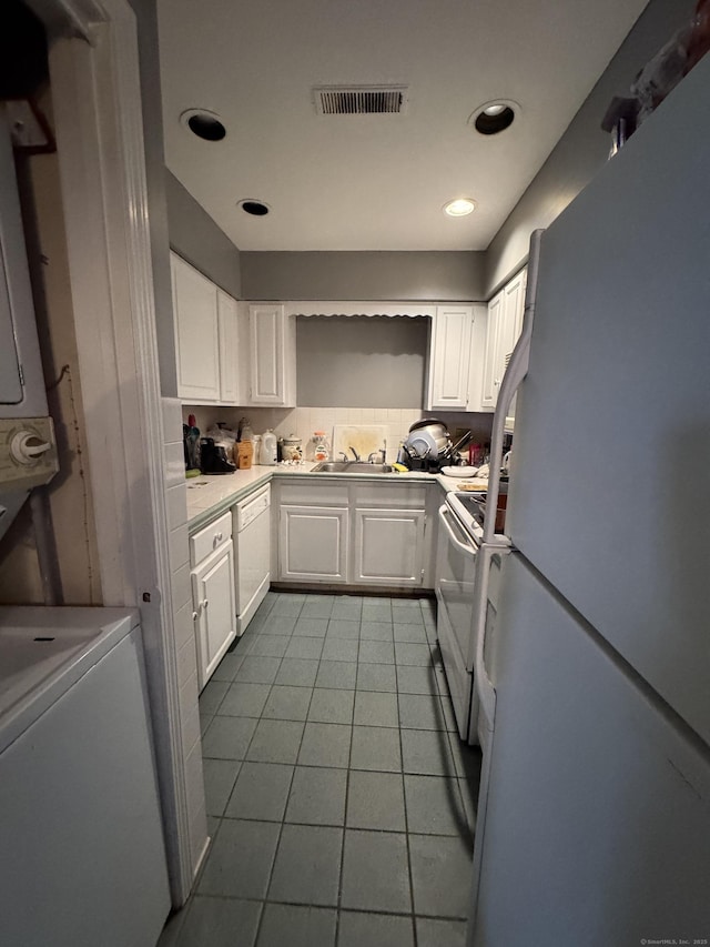 kitchen with light tile patterned floors, white cabinets, and white appliances