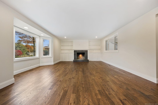 unfurnished living room with built in shelves and dark hardwood / wood-style flooring