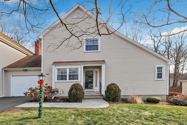 view of property with a garage and a front lawn