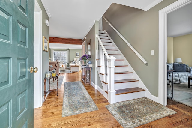 entryway with hardwood / wood-style floors and ornamental molding