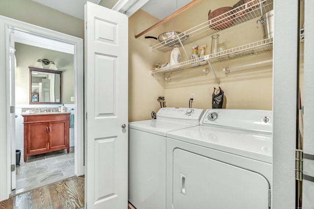 clothes washing area featuring washing machine and clothes dryer and light wood-type flooring