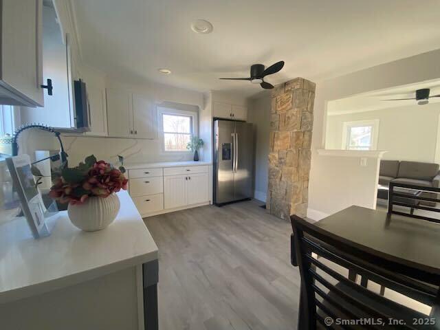 kitchen featuring white cabinetry, ceiling fan, light hardwood / wood-style floors, and stainless steel refrigerator with ice dispenser