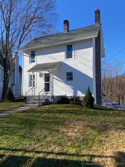 back of property featuring a lawn