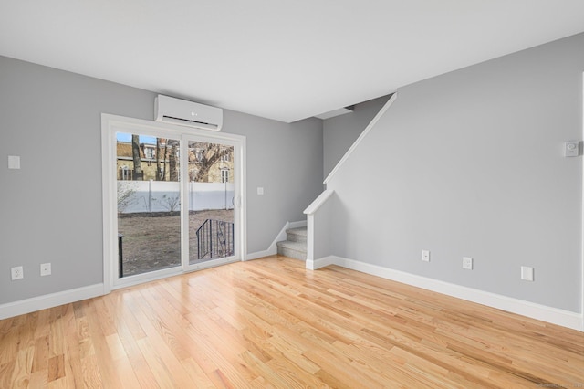 empty room featuring light hardwood / wood-style floors and an AC wall unit