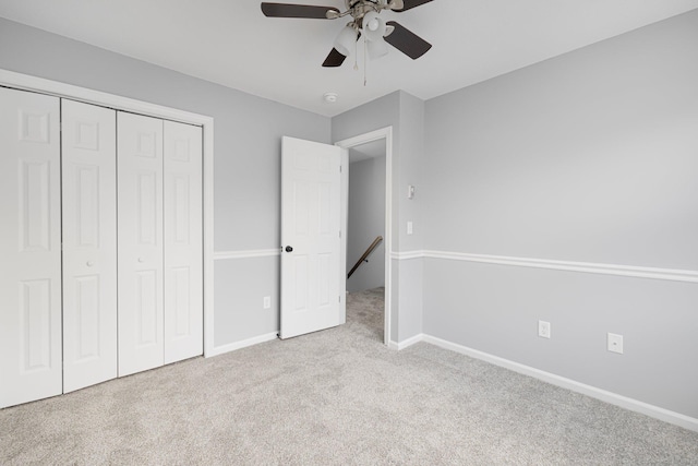 unfurnished bedroom featuring ceiling fan, a closet, and light carpet