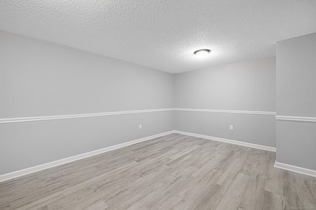 unfurnished room featuring a textured ceiling and light hardwood / wood-style floors