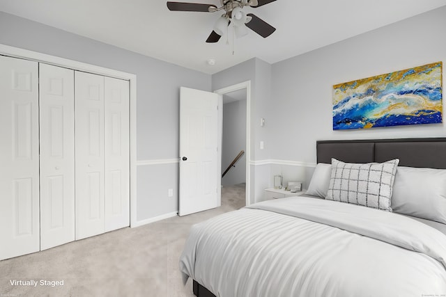 bedroom with ceiling fan, a closet, and light colored carpet