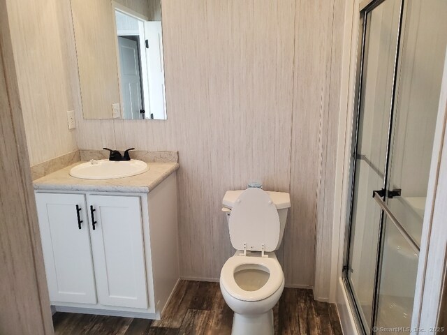 270 Boston Post Rd Unit 22, Waterford, CT 06385 - bathroom featuring hardwood / wood-style flooring, vanity, a shower with shower door, and toilet